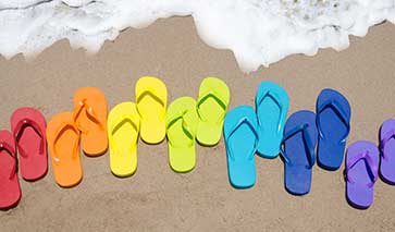 Multi-coloured flip flops on the beach