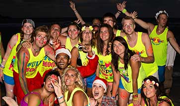 Partygoers at a full moon party in fluorescent colours