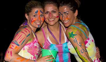 Three women at a party in fluorescent colours