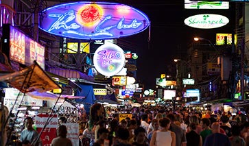 Busy street with bars and food stalls at night time