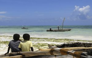 tefl students sat on beach looking at boats