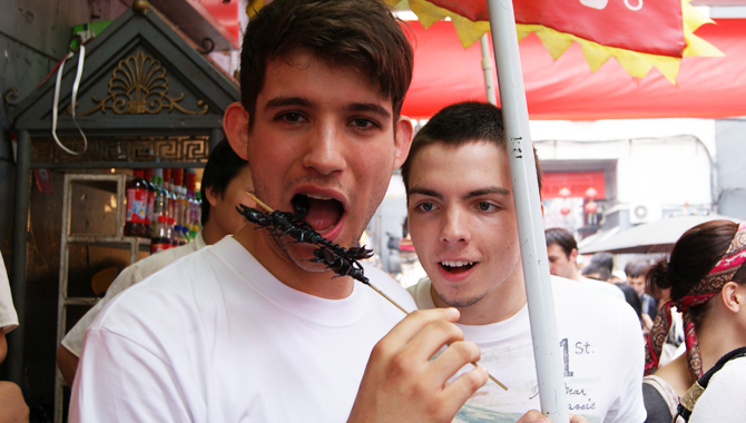 man eating chinese street food