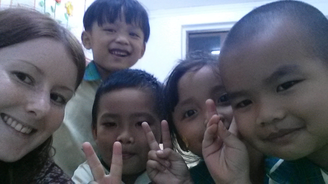 Cheeky TEFL students gather round for a selfie with i-to-i TEFL intern Ellen in Phnom Penh, Cambodia