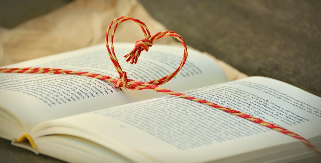 Open book with a string tied around it in the shape of a heart