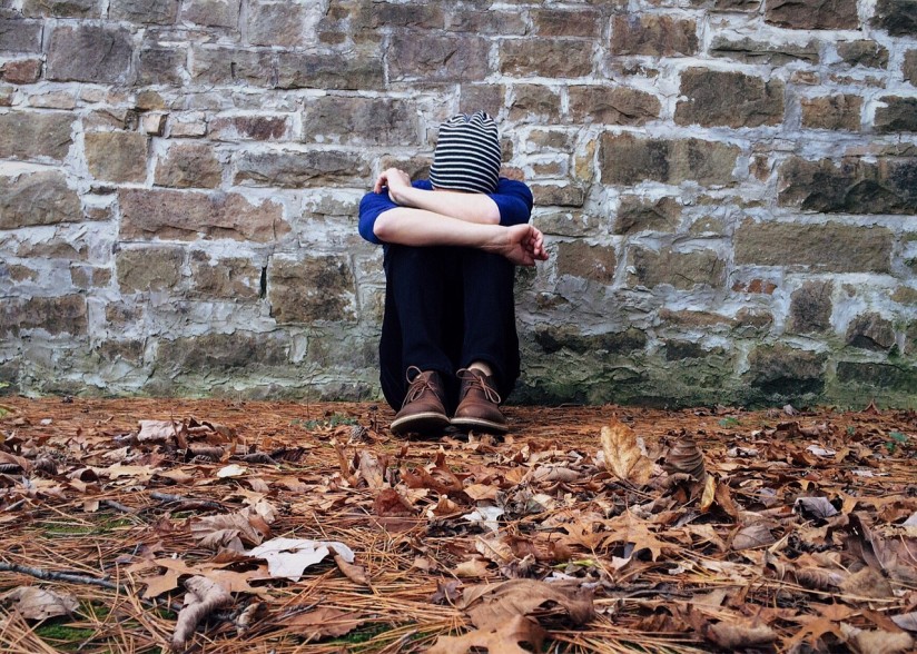 single person alone crouched on the ground