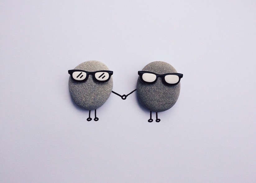 Two rocks with drawings round so they are holding hands 