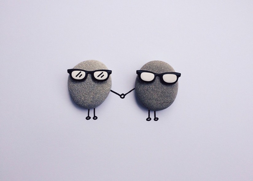 Two rocks with drawings round so they are holding hands