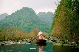 woman on boat rowing through lake