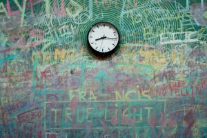 clock on a wall with graffiti