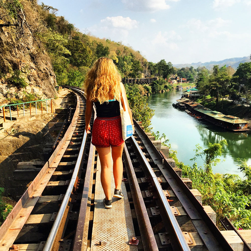 girl walking on rail in thailand