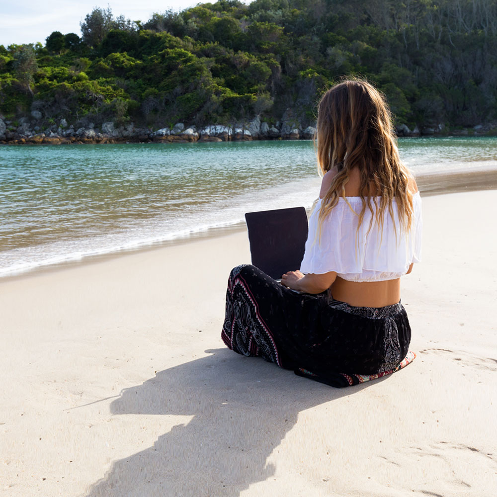 Girl on beach with laptop