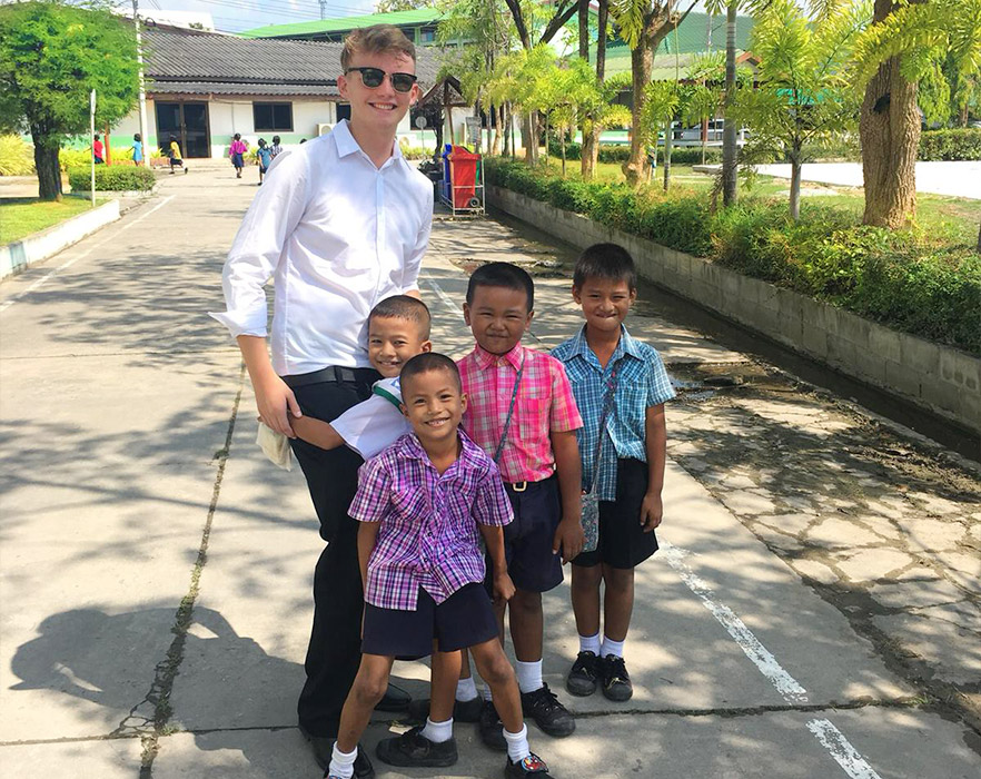 Young TEFL teacher outside with students