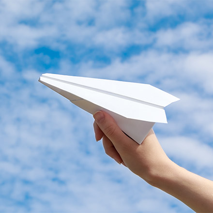 Girl launching paper plane