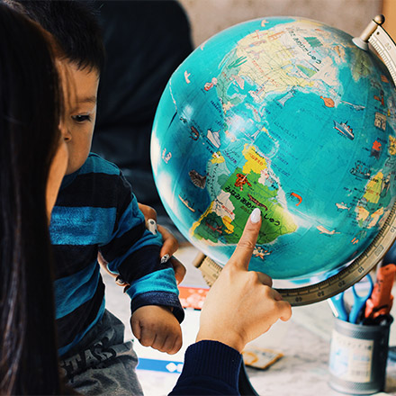 Woman showing globe to child