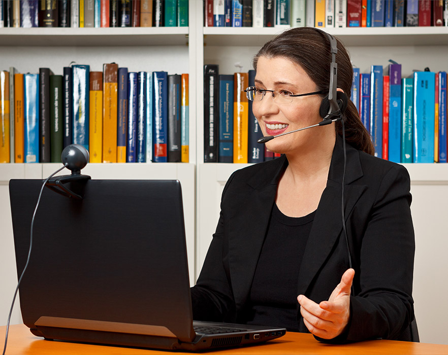 Woman with headset working on laptop