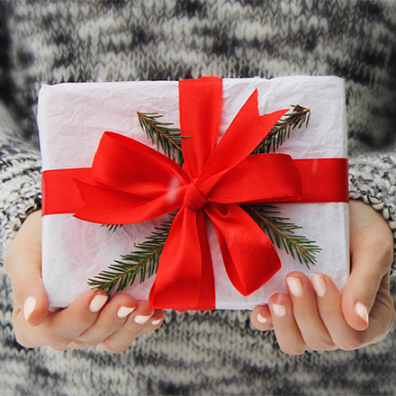 Woman holding wrapped up Christmas present