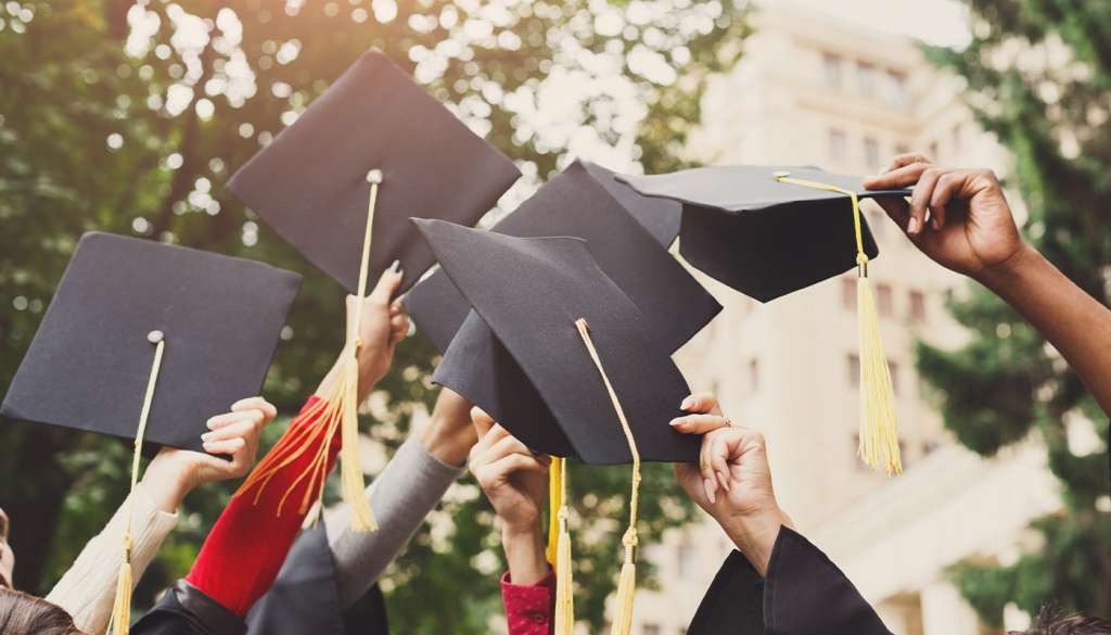 A group of graduates throwing graduations caps