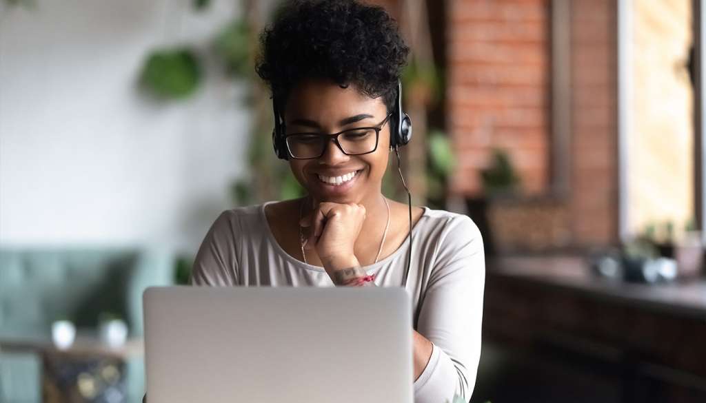 Woman using laptop and headset