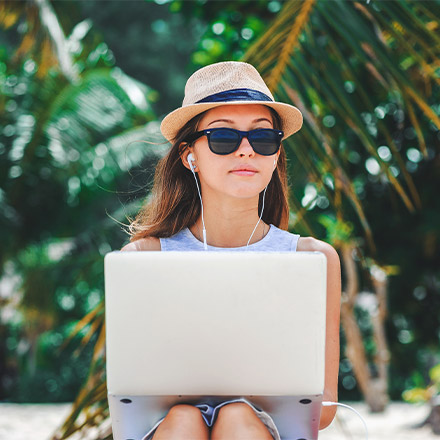 Woman using laptop on beach