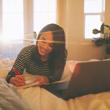 Woman using laptop in bed