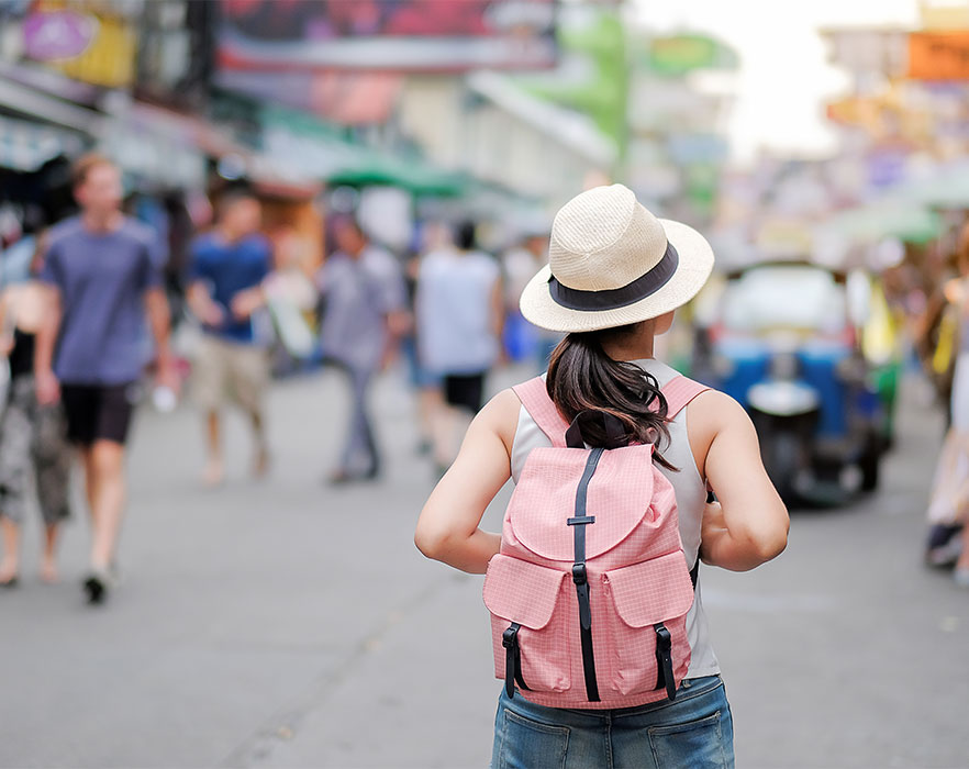 Woman walking through street with backpack