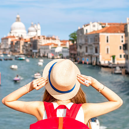 Woman with hat on looking over Grand canal, Venice