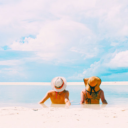 2 girls sunbathing on beach