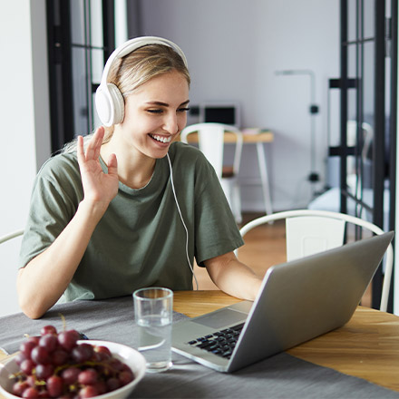 Woman with headset on using laptop