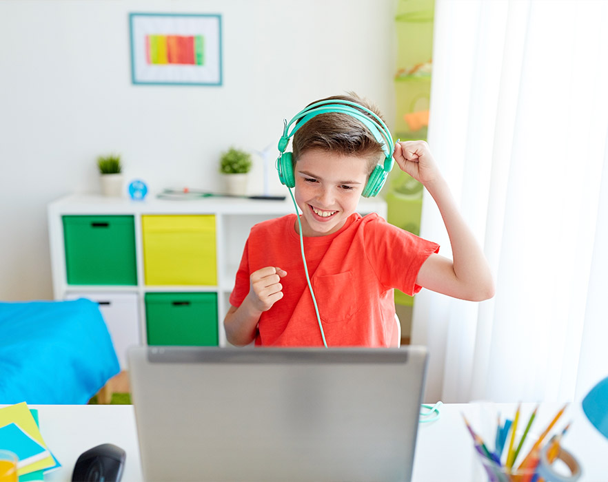 Boy in headphones having online English class through iPad