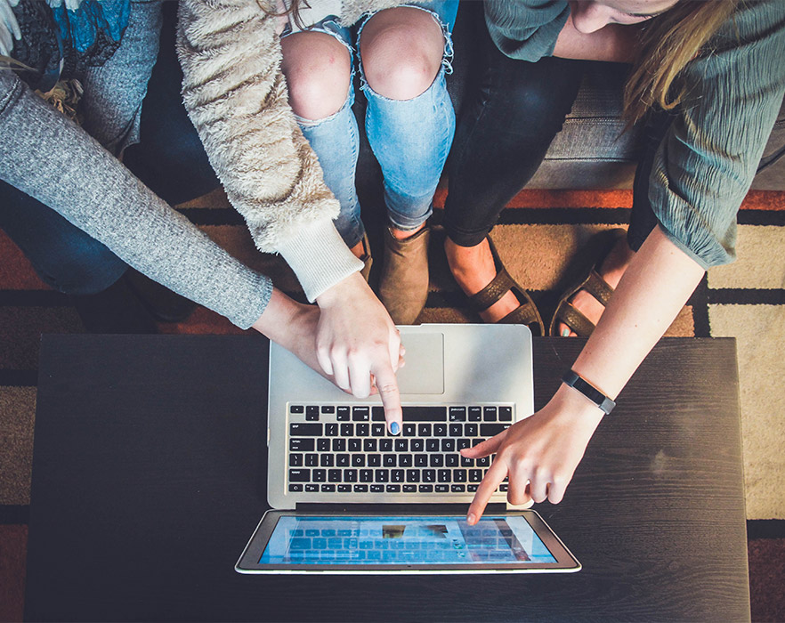 Friends pointing to laptop