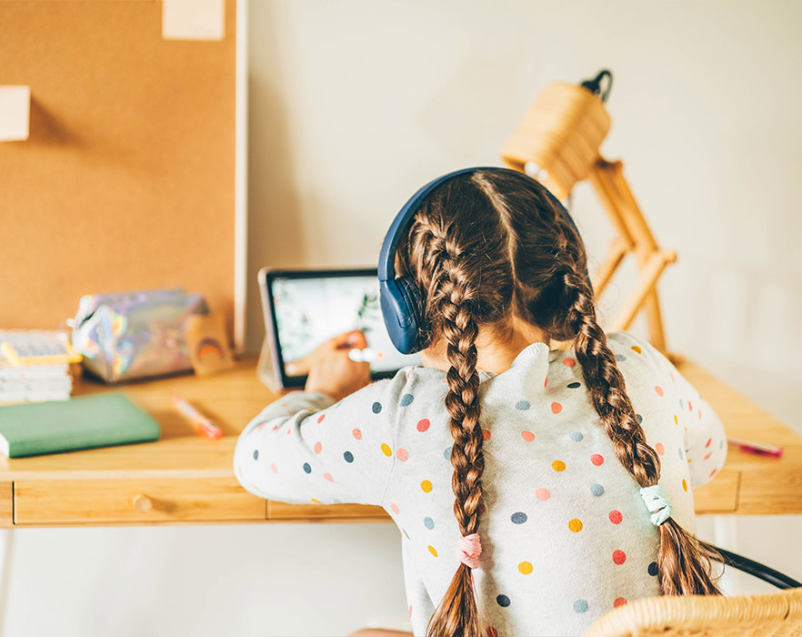 Girl sat at desk using iPad