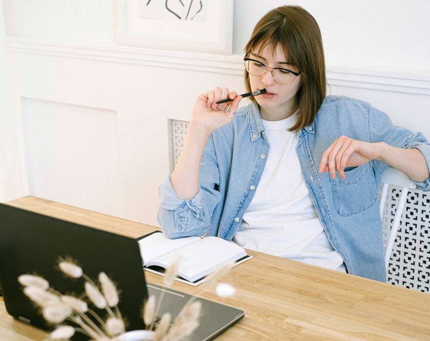 woman thinking near laptop