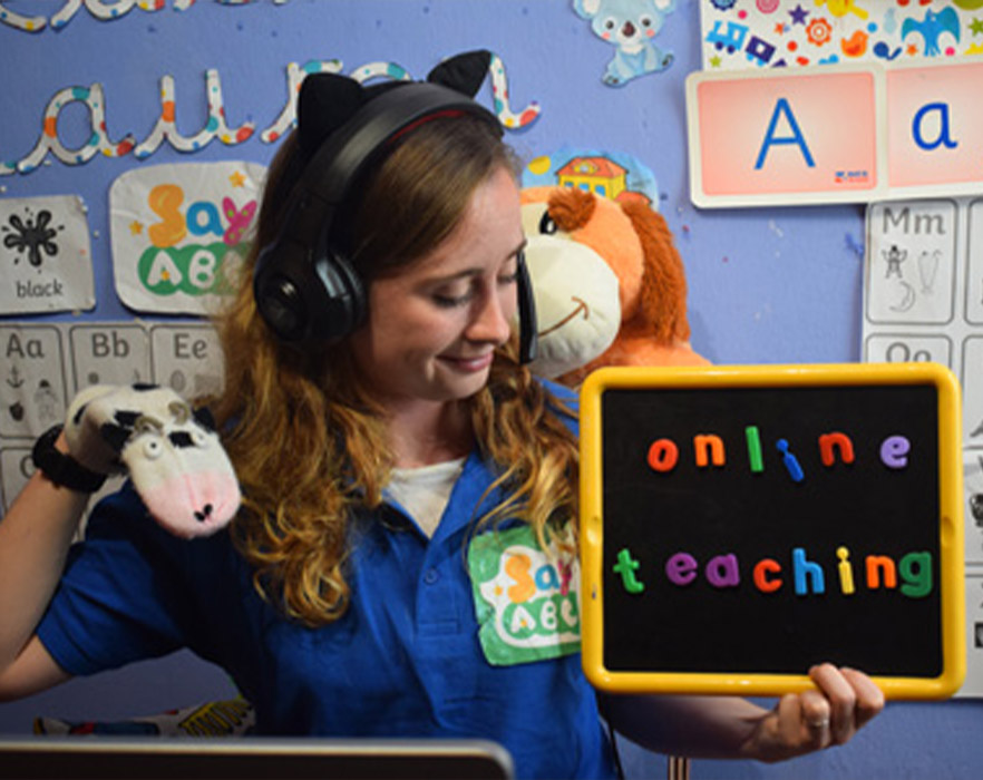 Online teacher holding up puppet and props