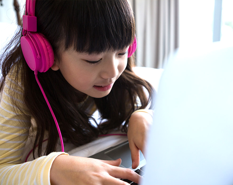 Young girl listening to audio through headphones