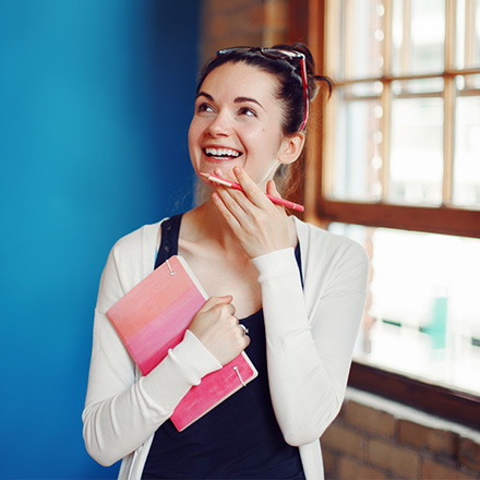 Young woman holding notepad and pen