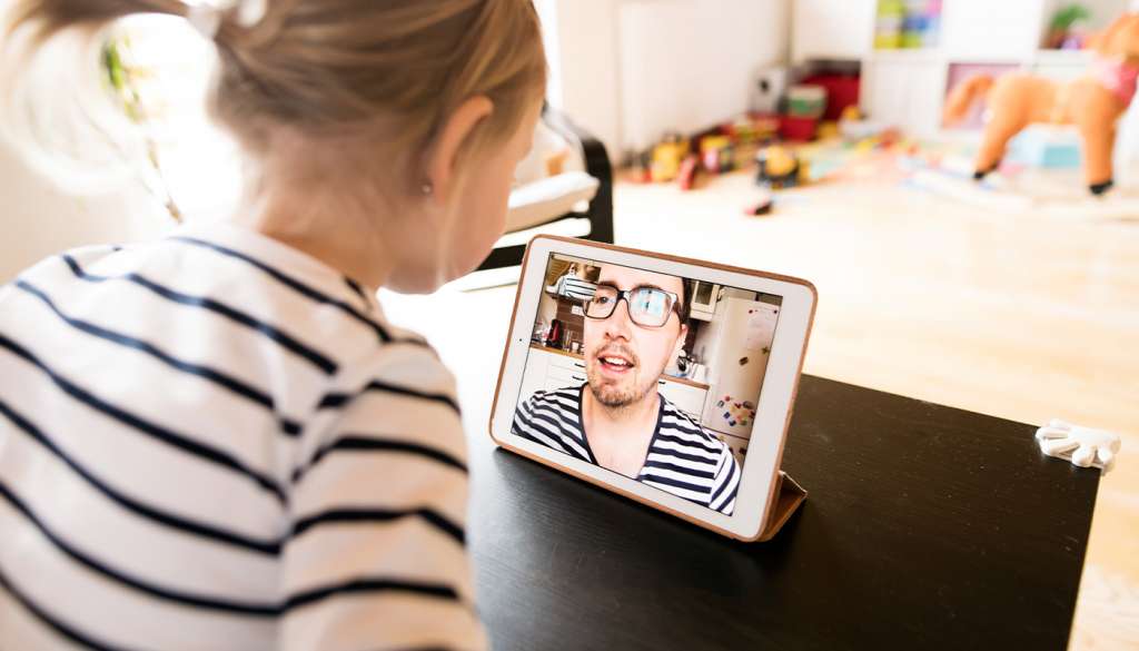 Young girl using iPad for online English lesson