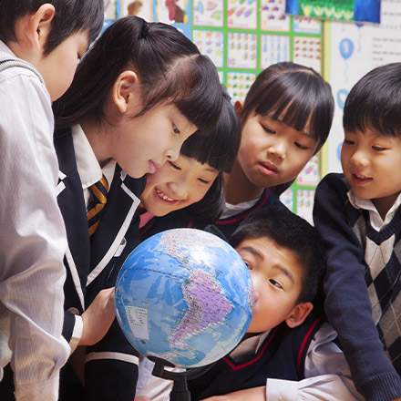 Young students looking at a globe