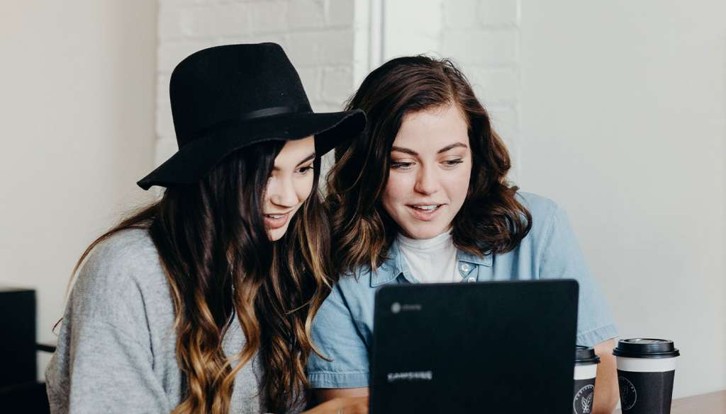 two girls looking at a laptop