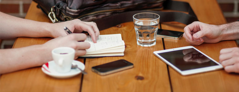 close up of a table with someone writing in a book