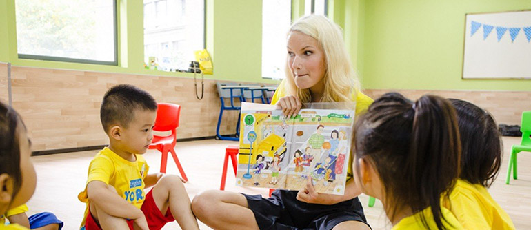teacher in the middle with a book reading to class