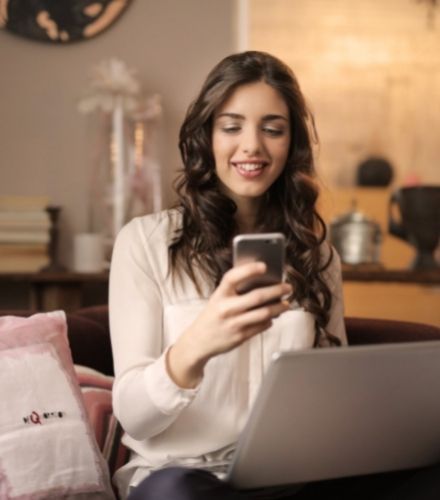 Woman on phone using her laptop