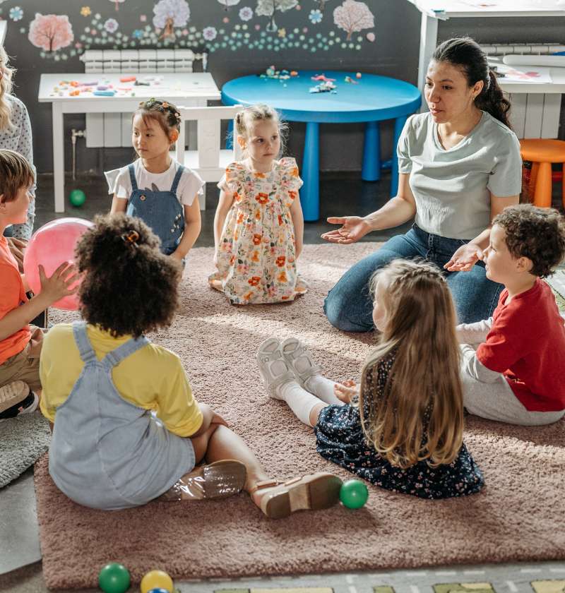 teacher sat on floor with students