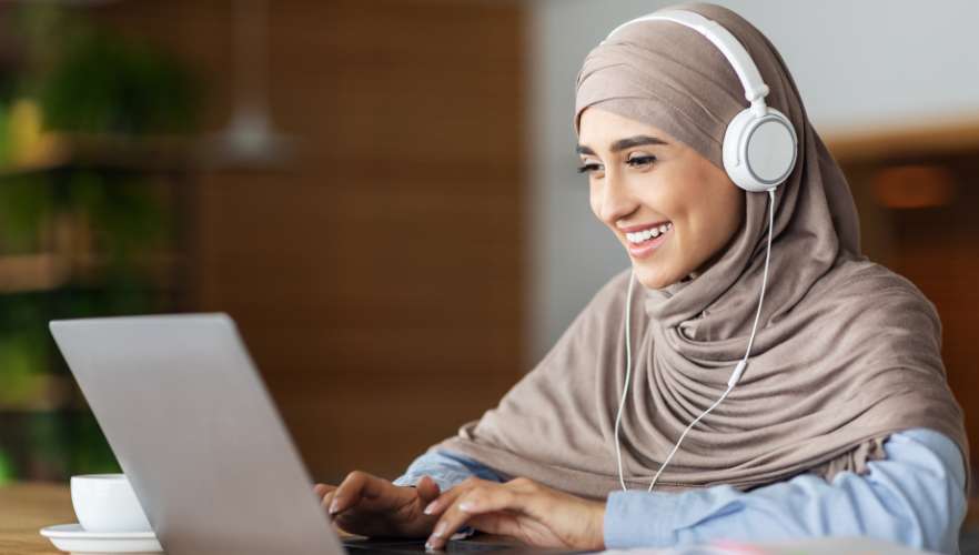 WOMAN SMILING AT LAPTOP